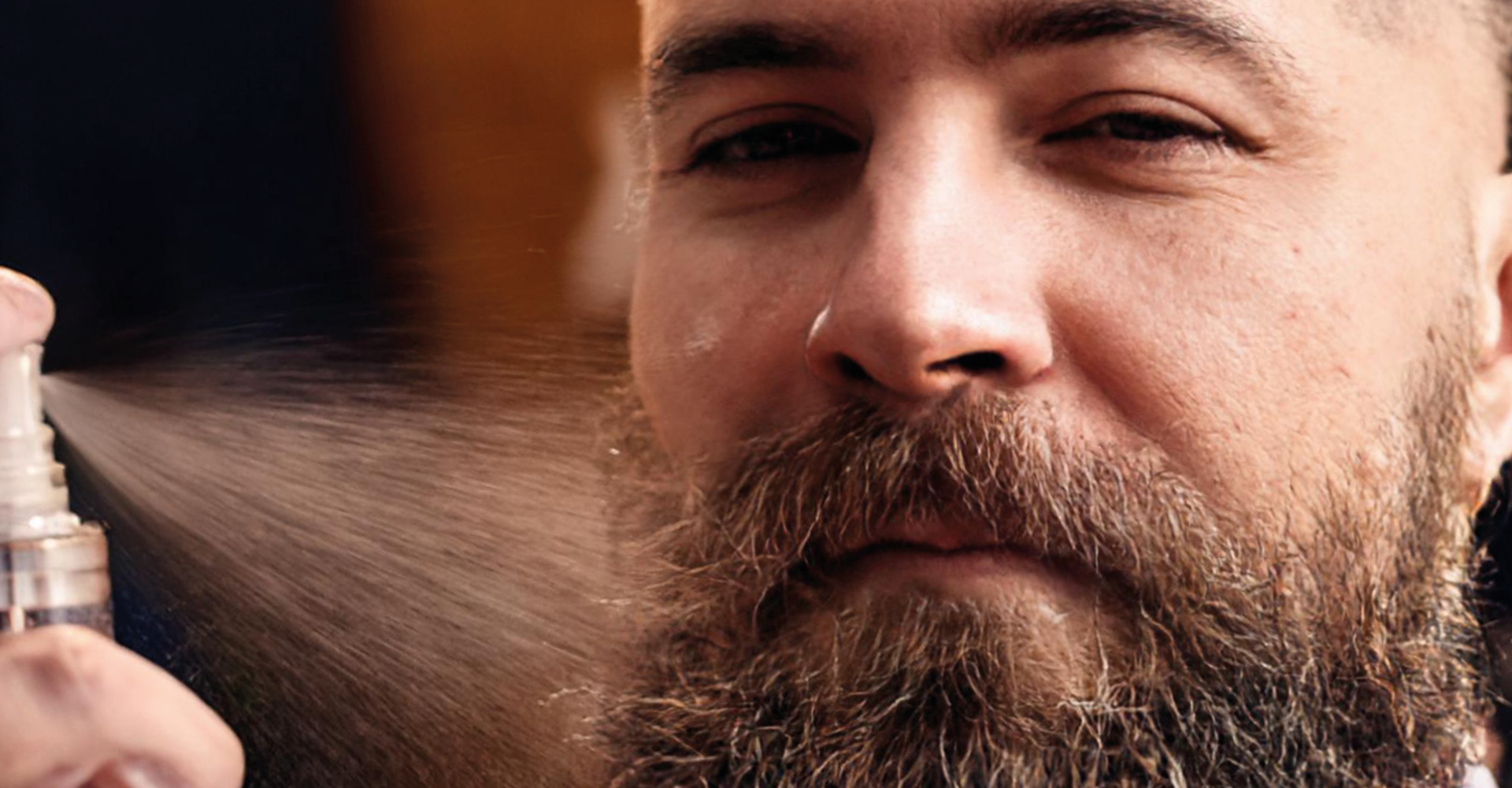 volto di un uomo, con barba lunga e a lato uno spruzzo dello spray